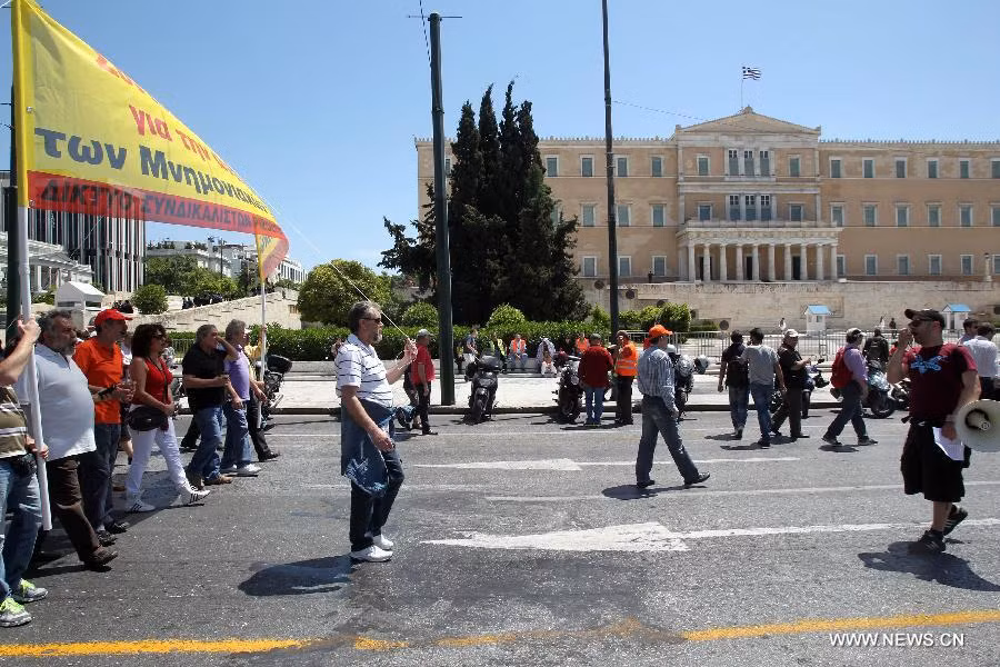 Protesters shout slogans and hold banners in front of the House of Parliament, in Athens, Greece, May 1, 2013. Greece is in the grip of a new 24-hour general strike on Wednesday, as the country’s largest unions of public and private sector workers ADEDY and GSEE mark Labor Day with anti-austerity rallies in central Athens and other major cities. (Xinhua/Marios Lolos)