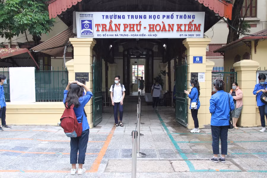 Thí sinh đầu tiên bước ra khỏi điểm thi tại trường THPT Trần Phú (Hoàn Kiếm, Hà Nội) trong tiếng vỗ tay động viên của đội ngũ tình nguyện viên.
