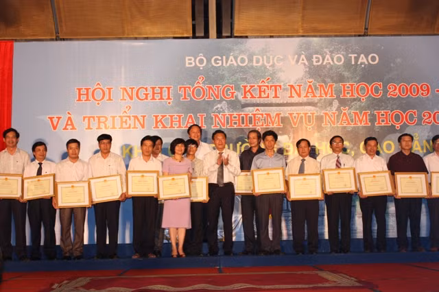 Bộ trưởng Bộ GD&ĐT Phạm Vũ Luận tặng bằng khen cho các đơn vị. Ảnh: gdtd.vn