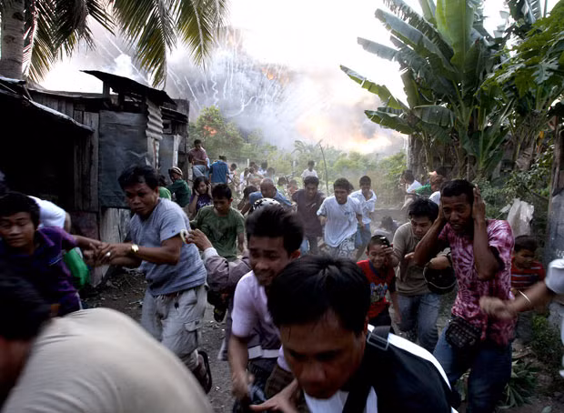 Những hình ảnh ấn tượng trong tuần ảnh 6 People flee as a warehouse full of pyrotechnics and fireworks explodes in Zamboanga in the southern Philippines. At least a dozen people were injured in the fire that gutted also ten houses.
