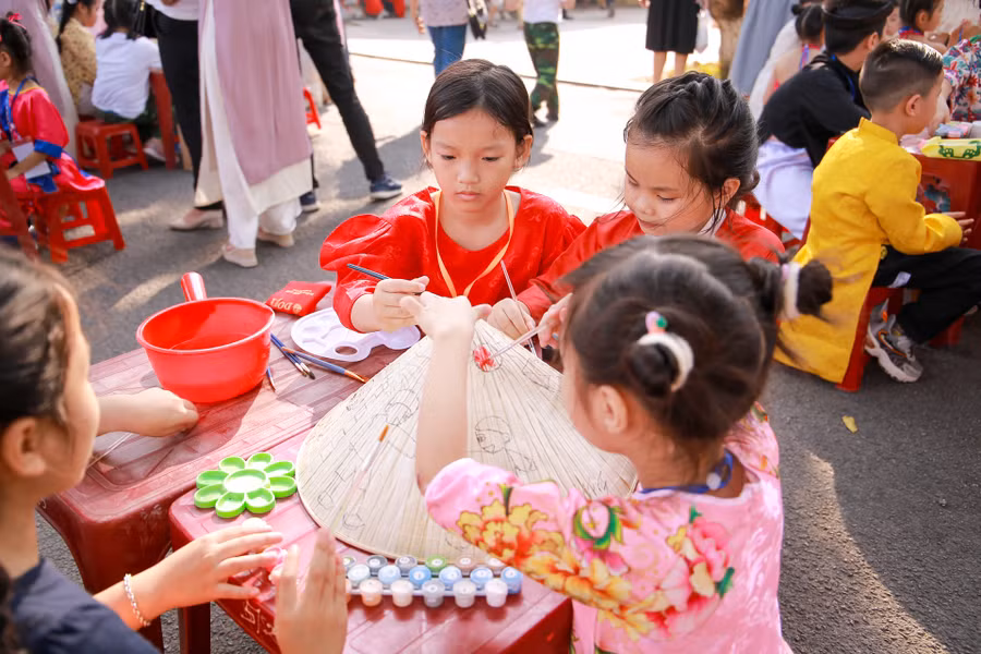 Tỉ mỉ tô từng chi tiết trên nón lá.