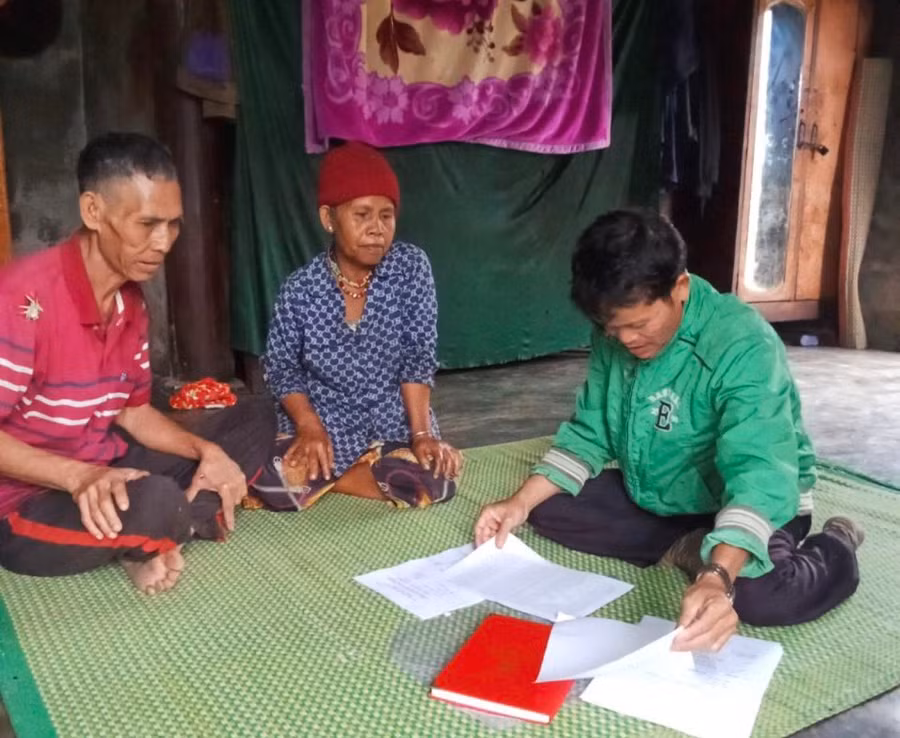 Cán bộ đến nhà người dân ở huyện miền núi A Lưới, tỉnh Thừa Thiên - Huế vận động học xóa mù chữ. (Ảnh: N.P)