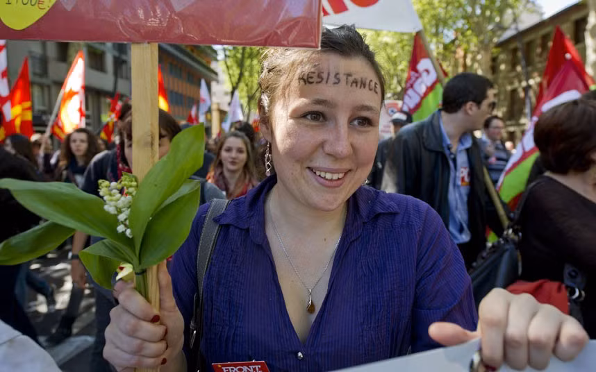 Ngày Quốc tế lao động trên khắp thế giới ảnh 2 A protester holds lily of the valley as she takes part in a march during the annual May Day event in Toulouse, southern France