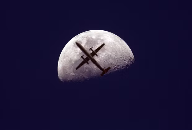 Những hình ảnh ấn tượng trong tuần ảnh 1 Fly me to the moon: Christopher Tomas spent months planning this photograph of a passenger jet flying past the moon that he took on the Blackbutt range in Queensland, Australia.