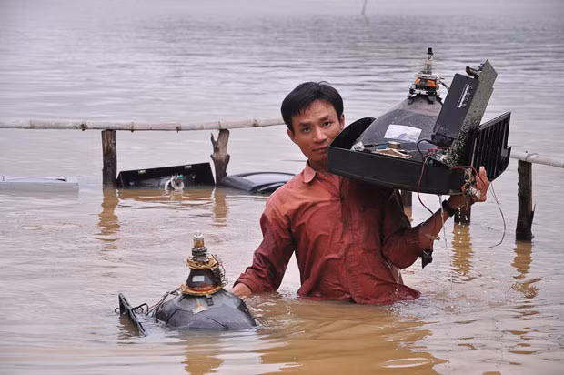 Lụt lội ở Philippines, Thái Lan và Việt Nam trước sức mạnh của Megi ảnh 5 A man tries to salvage TV sets from his flooded repair shop in Quang Binh province, Vietnam