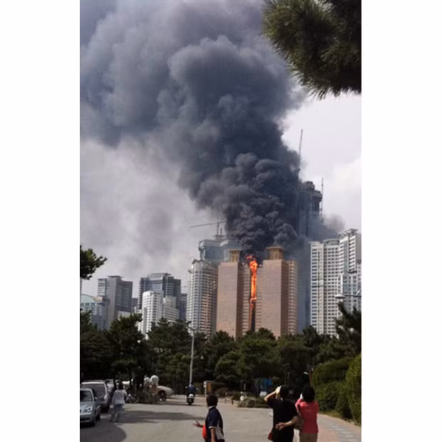 Những hình ảnh ấn tượng trong tuần ảnh 11 People watch a burning apartment building in Busan, South Korea