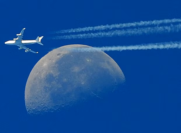 Những hình ảnh ấn tượng trong tuần ảnh 2 A Boeing 747 flies in front of the moon, as seen from Martigues, near Marseille, southern France