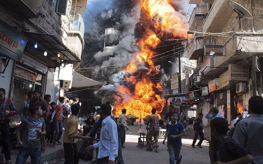 Một đám cháy tại cửa hàng xăng dầu ở gần Aleppo (Syria) Residents look at a a fire at a petrol and oil shop in the Bustan Al-Qasr neighbourhood of Aleppo, Syria
