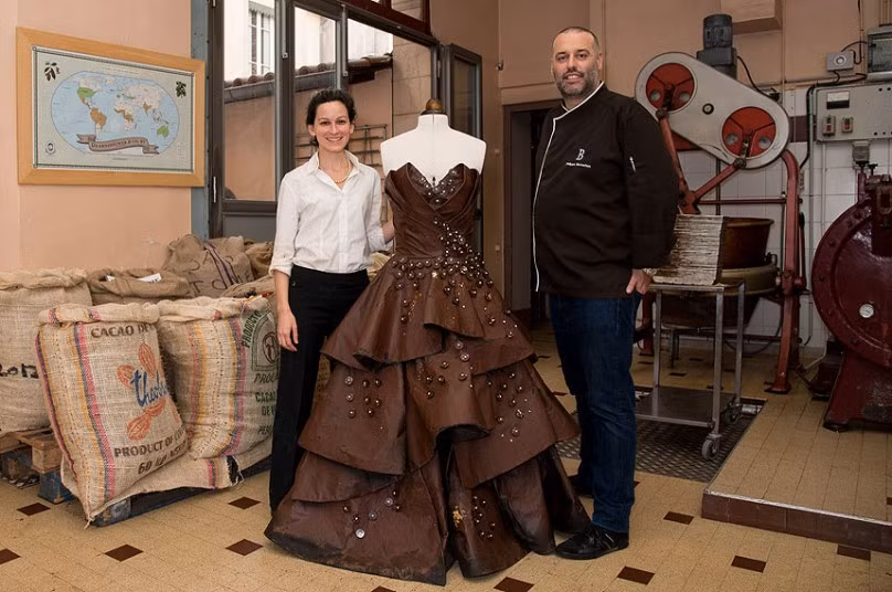 Nhà sản xuất socola Philippe Bernachon và nhà thiết kế Florencia Soerensen đã hợp tác để tạo ra chiếc váy socola tại Lyon (Pháp). Chiếc váy nặng 6 kg này sẽ được vận động viên quần vợt Bartoli mặc tại triển lãm socola Paris vào ngày 29/10 tại Porte de Versailles. Chocolate maker Philippe Bernachon and designer Florencia Soerensen collaborate to create a chocolate dress in Lyon, France. The six kilogram chocolate dress is made from golden leafs and savage silk and is to be worn by former professional tennis player Marion Bartoli at the Paris chocolate trade show Salon du Chocolat on October 29 at Porte de Versailles.