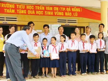 Ông Lê Anh- Phó Chủ tịch UBND Quận Hải Châu trao sách vở cho học sinh tại trường Tiểu học Nguyễn Thị Bảy.