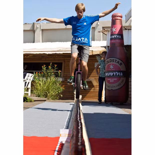 Lutz Eichholz rides a unicycle along upright beer bottles in Tel Aviv during his attempt to break the world record. Eichholz set a new Guinness world record by riding his unicycle over a 8.93-metre-long row of 127 beer bottles. According to organisers, the previous record was 7.99 metres.