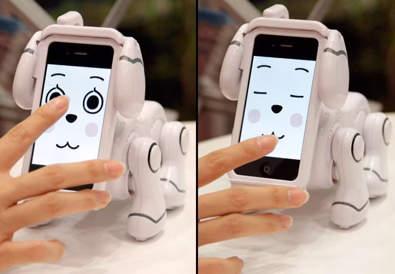 Bandai’s ’SMARTPET’ robot dog is demonstrated at the International Tokyo Toy Show. The screen of an iPhone becomes the robot’s head and can display changing facial expressions.