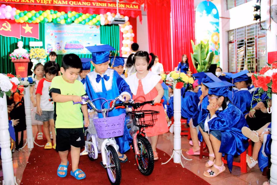 Các bé khối lớp Chồi hồ hởi đón nhận quà và đồ chơi do anh chị lớp Lá trao tặng.