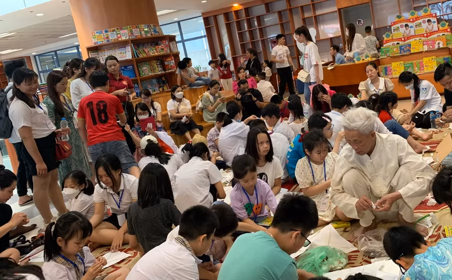 Học sinh, phụ huynh được trải nghiệm làm diều giấy dưới sự hướng dẫn, giúp đỡ của các nghệ nhân.