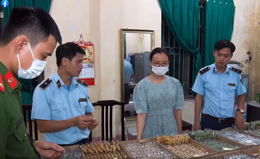 Phạm Thị Phụng cùng số bánh không rõ nguồn gốc bị cơ quan chức năng thu giữ.