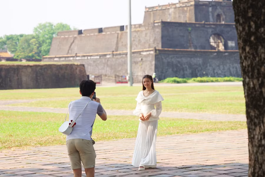 Chụp ảnh cho bạn gái trong khung cảnh cổ kính mát mẻ tại Hoàng thành Huế. (Ảnh: L.N).
