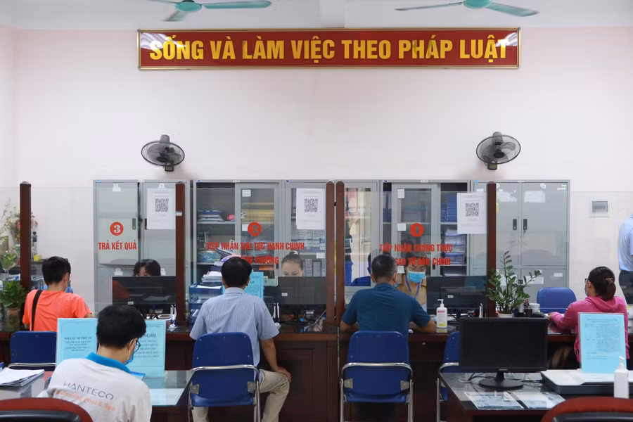 Do có không gian khá rộng, nên người dân ngồi giãn cách tại trụ sở UBND để đợi đến lượt mình.