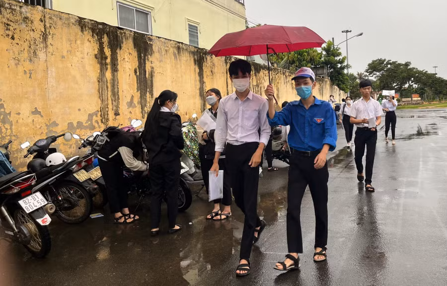 Tình nguyện viên che ô cho thí sinh vào điểm thi. Tình nguyện viên che ô cho thí sinh vào điểm thi.