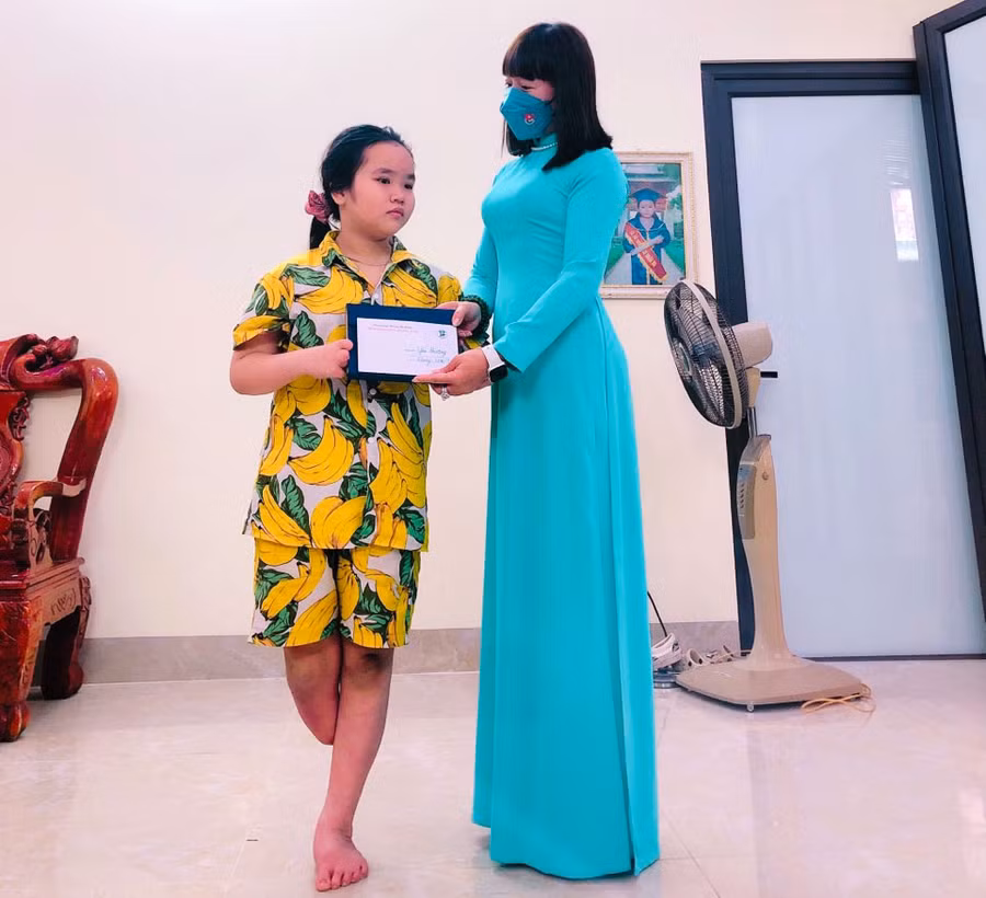 Cô Nguyễn Thị Huyền trao tặng phần quà cho một học sinh đang học tập tại trường THCS An Khánh sáng ngày 26/3.