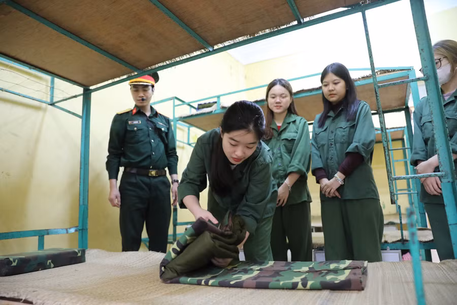Gấp chăn màn đúng quy định là công việc đầu tiên của sinh viên để làm quen với môi trường trong quân đội.