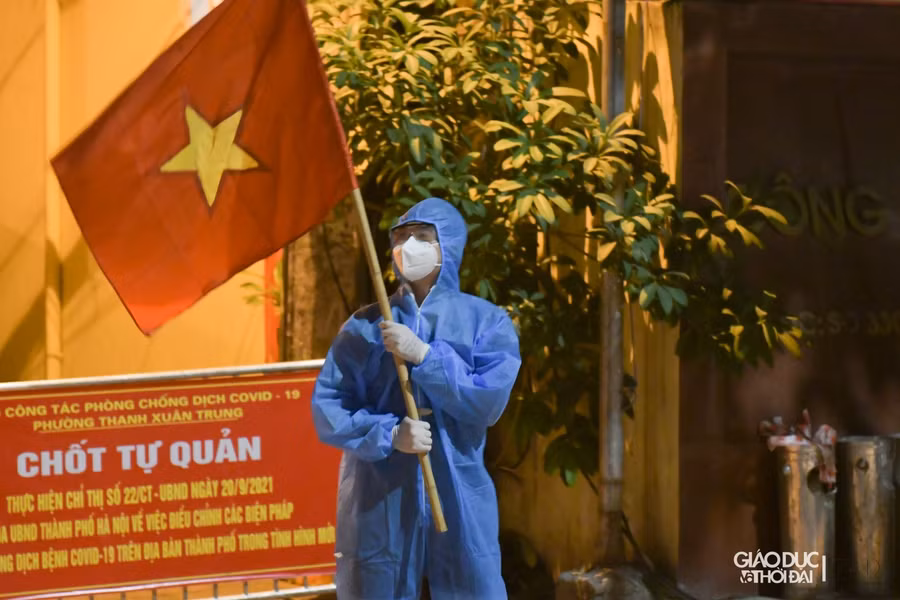 Tình nguyện viên trên tay cầm quốc kỳ với quyết tâm "Việt Nam chiến thắng đại dịch.