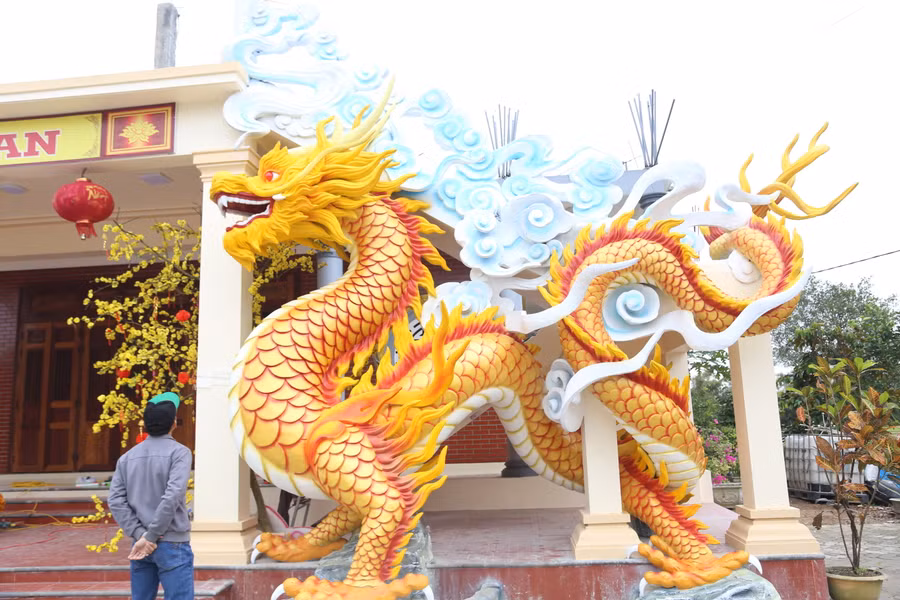 Linh vật rồng có màu vàng chủ đạo, xung quanh là những đám mây trắng xen lẫn mây xanh. Linh vật rồng có màu vàng chủ đạo, xung quanh là những đám mây trắng xen lẫn mây xanh.