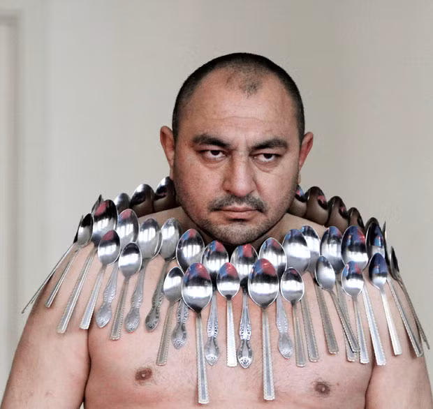 Etibar Elchiyev poses with 50 metal spoons magnetized to his body during an attempt to break the Guinness World Record for 