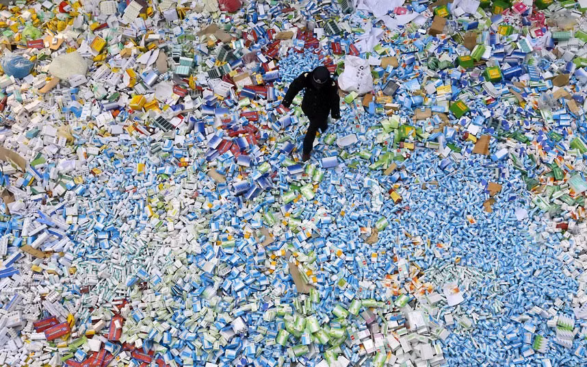A law enforcement officer walks over counterfeit drugs to be destroyed in Beijing. Chinese drug authorities destroyed more than 50 tons of counterfeit drugs - confiscated over the past two years. Police detained more than 1,900 people suspected of making or selling fake drugs in a nationwide bust last year.