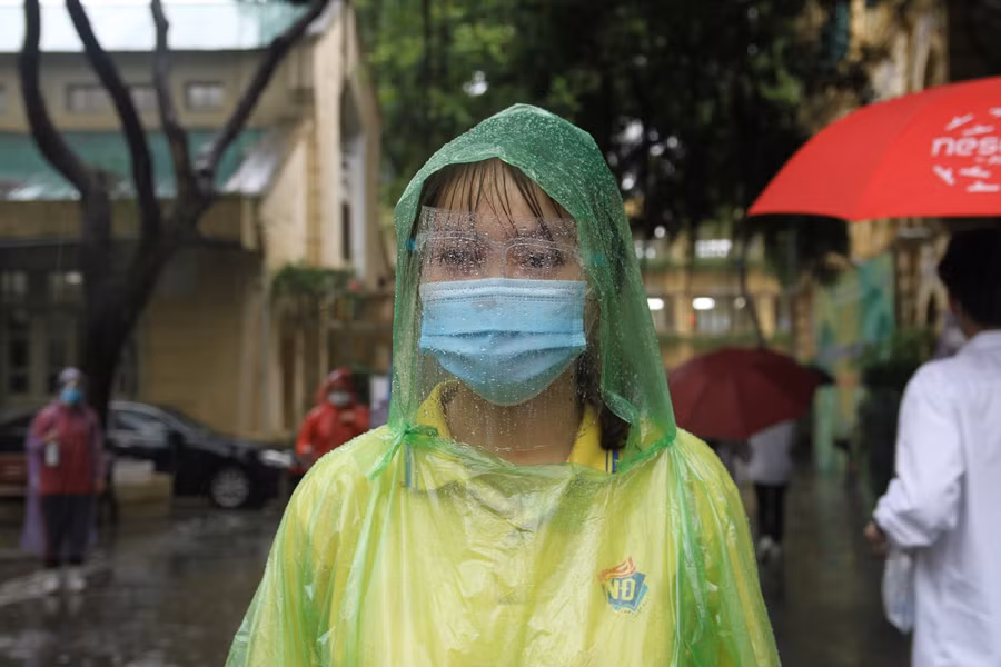 Lực lượng tình nguyện tại điểm thi trường THPT Việt Đức làm công tác hỗ trợ thí sinh tham gia dự thi dưới cơn mưa như trút nước.