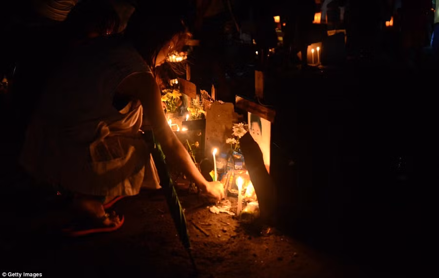 A young girl laces a candle as relatives visit the grave of a loved one who was killed during Typhoon Haiyan at a flooded mass grave on Christmas Eve Read more: http://www.dailymail.co.uk/news/article-2528947/Crowds-gather-Bethlehem-Christmas-Eve-celebrations-amid-calls-peace-Middle-East.html#ixzz2oS3frX2q Follow us: @MailOnline on Twitter | DailyMail on Facebook