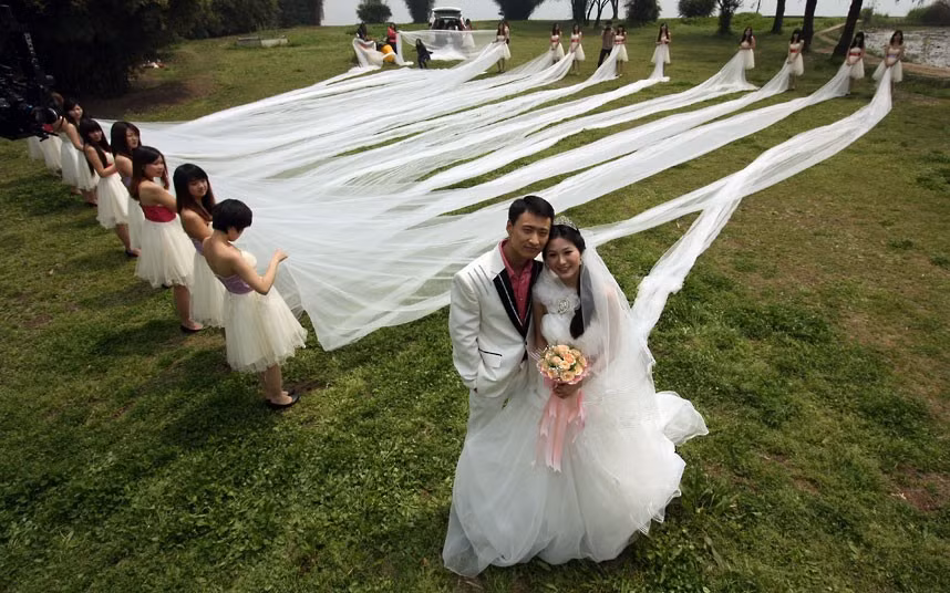Những hình ảnh ấn tượng trong tuần ảnh 7 Newlyweds pose for photos at Wuhan Botanical Garden in China. The bride wore a dress with a 520-metre-long train.