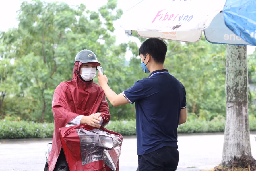 Thí sinh được kiểm tra thân nhiệt, khử khuẩn tay trước khi vào điểm thi.