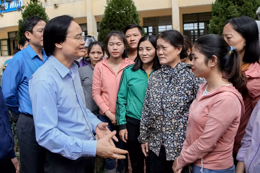 Bộ trưởng Phùng Xuân Nhạ chia sẻ vất vả, khó khăn cùng cán bộ, giáo viên, nhân viên trường Tiểu học Hàm Ninh. Ảnh: Thế Đại