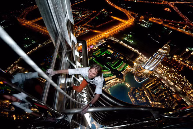 Những hình ảnh ấn tượng trong tuần ảnh 4 French Spiderman Alain Robert completes his latest climbing feat - scaling the tallest building in the world. The 47-year-old took six hours to ascend the 828m (2,717ft) tall Burj Khalifa in Dubai. Wind delayed his ascent for several hours but didn’t stop him from successfully reaching the top of the tapered spire above the 160th floor of the building. Alain is famous for climbing buildings around the world, which he normally does just using his bare hands and climbing shoes. However, for this attempt he had to use a rope and harness in order to comply with safety regulations.