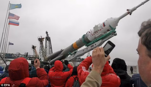 Onlookers take a snap as the Russian Soyuz TMA-21 rocket is mounted Read more: http://www.dailymail.co.uk/sciencetech/article-1372645/Russia-prepares-launch-Soyuz-space-ahead-50th-anniversary-manned-flight-Yuri-Gagarin.html#ixzz1ITSzhIvl