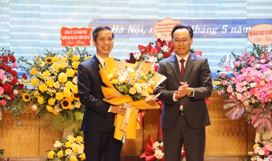 Thứ trưởng Hoàng Minh Sơn (bên phải) trao quyết định công nhận Chủ tịch Hội đồng Trường ĐH Giao thông vận tải và tặng hoa chúc mừng PGS.TS Nguyễn Thanh Chương.