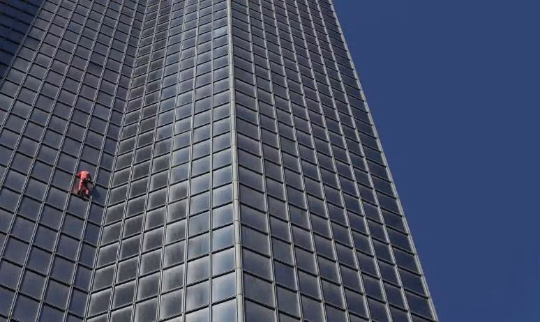 Ông Alain Robert leo lên tòa nhà chọc trời Tour Total ở Paris vào ngày 17/9. Ảnh: Lucien Libert/ Reuters. Ông Alain Robert leo lên tòa nhà chọc trời Tour Total ở Paris vào ngày 17/9. Ảnh: Lucien Libert/ Reuters.