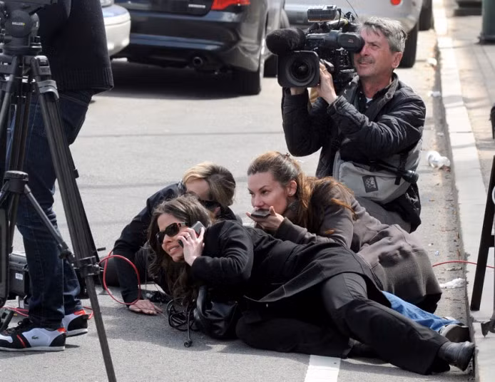 Những hình ảnh ấn tượng trong tuần ảnh 2 Journalist take cover during the manhunt for the second suspect of the Boston Marathon bombing in Watertown