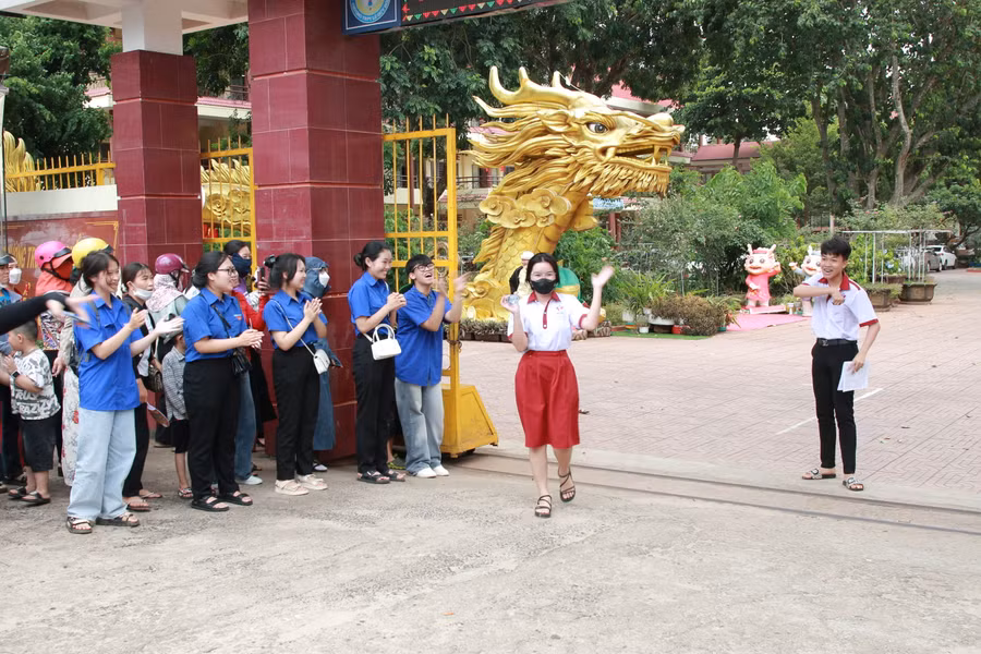Các thí sinh rạng ngời trước sự cổ vũ của các tình nguyện viên khi rời khỏi khu vực thi. (Ảnh: TT)