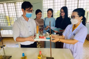 Giáo viên môn Vật lý Trường THPT Lê Quý Đôn nhận thiết bị dạy học từ chị Phạm Thị Kim Dung (mặc áo blouse). Ảnh: Thành Tâm