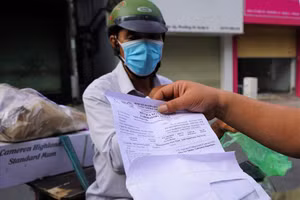 Cán bộ công an đang kiểm tra giấy tờ của người dân tại chốt trên đường Lê Văn Sĩ, Quận 3 trong chiều 9/7. Ảnh: LĐO.

