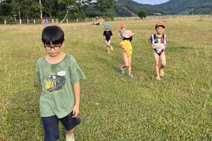 Các em nhỏ xắn quần, kéo áo để tránh bị cỏ may đâm vào (ảnh: HT).