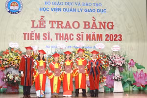 GS.TS Phạm Quang Trung, Giám đốc Học viện Quản lý giáo dục (ngoài cùng bên phải) và PGS.TS Trần Hữu Hoan, Phó Giám đốc Học viện (ngoài cùng bên trái) trao bằng tốt nghiệp cho các tân tiến sĩ.