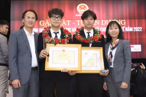 Hai em Phạm Nguyễn Quang Huy và Phạm Nguyễn Gia Bảo cùng bố mẹ trong lễ tuyên dương học sinh đạt giải Olympic và KHKT quốc tế năm 2022. Ảnh: Đình Tuệ. 