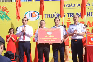 Tiến sĩ Lê Xuân Trung (thứ 3 từ phải sang) thay mặt Trường THPT Lê Lợi trao tặng 1.500 lá cờ Tổ quốc cho đại diện Bộ Tư lệnh Cảnh sát biển Việt Nam để gửi tới các chiến sĩ hải đảo Trường Sa thân yêu.