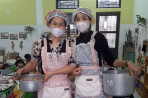 Nhân viên trường học Trường Mầm non Hoa Phượng tham gia hỗ trợ ăn bán trú cho trẻ. Ảnh: NVCC