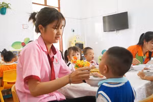 Trần Thị Diễm Quỳnh, sinh viên thực tập tại Trường Mầm non Thạnh An, cho trẻ ăn sáng. Ảnh: Mạnh Tùng