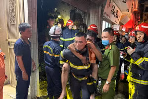 Thượng úy Nguyễn Viết Quân cõng ông Đỗ Đức Kiện đang dần ngất lịm thoát khỏi đám cháy.