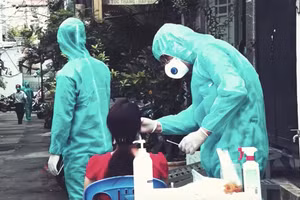 Nhân viên y tế lấy mẫu xét nghiệm những người dân sống cùng hẻm với bệnh nhân nhiễm Covid-19 sinh sống. Ảnh minh hoạ HCDC