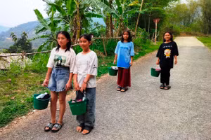 Nữ sinh Trường PTDTBT-THCS Trung Lý (Mường Lát, Thanh Hóa) xách xô ra suối để tắm giặt vào buổi chiều hằng ngày. Ảnh: NTCC